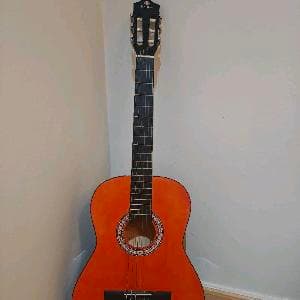 Unistar classic guitar with a stand and two picks